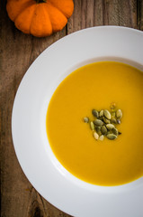 Pumpkin soup on wooden background
