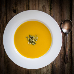 Pumpkin soup on wooden background