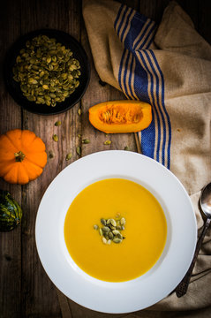 Pumpkin soup on wooden background