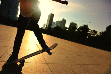 woman skateboarder skateboarding at sunrise city 