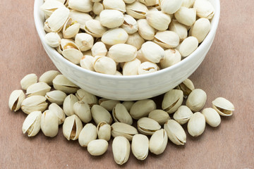 Pistachio nuts on wooden surface