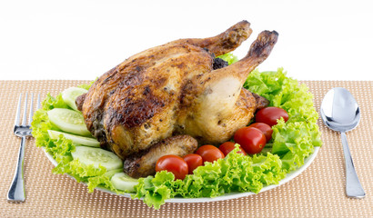 Whole roasted chicken garnished with fresh cucumbers, wine tomat