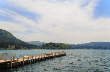 lone pier on a beautiful lake with greenish water surrounded