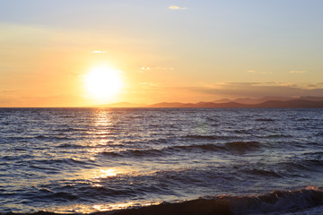 Obraz na płótnie Canvas Huge sun sets in the Aegean Sea.