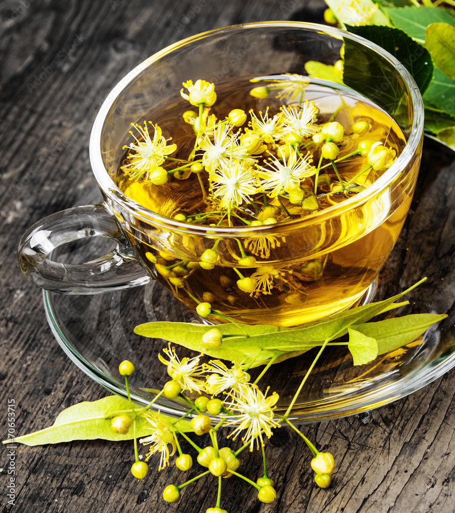 Wall mural a cup with linden tea on an old wooden table