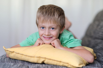 Fototapeta premium süßer kleiner junge liegt auf dem sofa