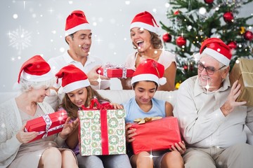 Composite image of excited family exchanging gifts at christmas