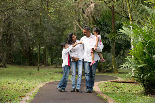 Happy Indian Family Walking Outdoor In The Park