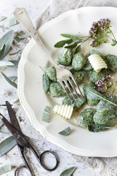 homemade spinach dumplings with sage, butter curls and flowers