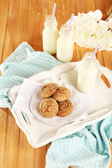 Milk and cookies on tray on table