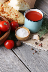 Homemade tomato juice in color mug, bread sticks, spices and