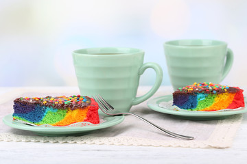 Delicious rainbow cake on plate, on table, on light background