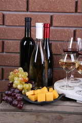 Bottles and glasses of wine, cheese and ripe grapes