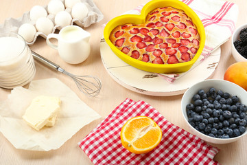 Baking tasty pie and ingredients for it on table in kitchen
