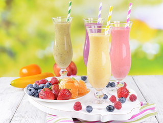 Delicious berry cocktails on table on bright background
