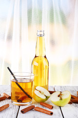 still life with apple cider and fresh apples on wooden table