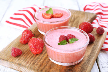 Delicious berry mousse in bowls on table close-up