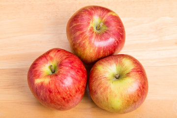 Naklejka na ściany i meble Three Red Apples on Wood Table