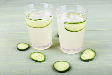 Two glasses of cucumber cocktail on wooden background