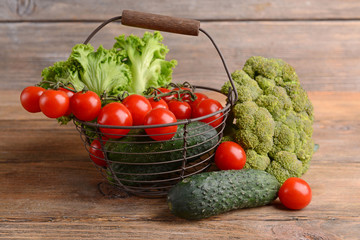 Vegetables in wicker basket on wooden background