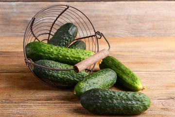Cucumbers in wicker basket on wooden background