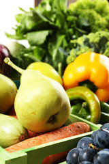 Fresh organic vegetables and fruits in wooden boxes, close up