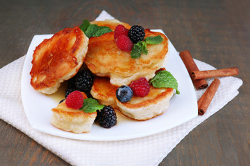 Obraz na płótnie Canvas Tasty pancakes with fresh berries, honey and mint leaf