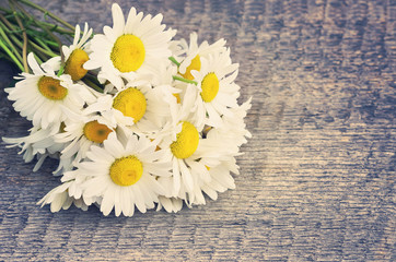 Bouquet of daisies on the board in vintage style
