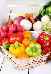 Vegetables in crate and in basket on white wooden box