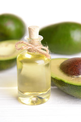 Avocado oil on table on light background