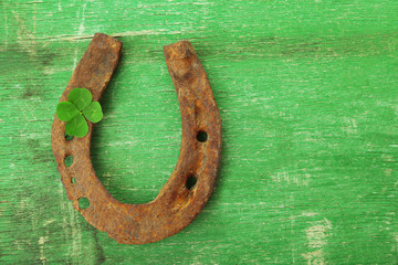 Old horse shoe,with clover leaf, on wooden background © Africa Studio