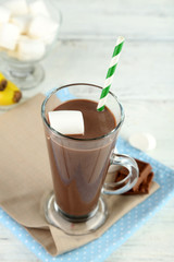 Chocolate drink with marshmallows in mug, on wooden background