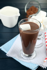 Chocolate drink with marshmallows in mug, on wooden background