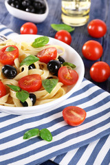 Spaghetti with tomatoes, olives and basil leaves