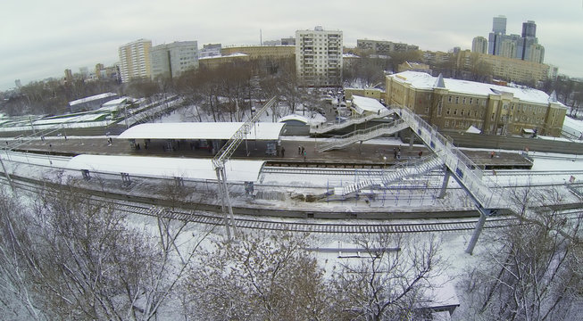 Snow-covered railway platform with a pedestrian bridge