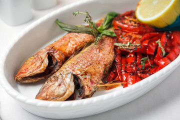 Fried fish with red peppers and lemon.
