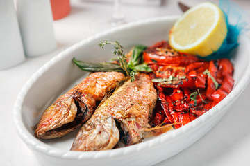 Fried fish with red peppers and lemon.