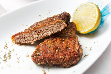 Fried veal medallion cut with lemon.