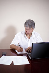 Mature businessman working with laptop in his office