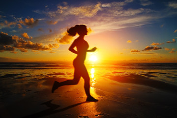 Fototapeta na wymiar Running girl at sunset silhouette