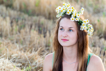 girl with  wreath of daisies in a  field