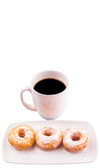 A mug of coffee and homemade doughnut with sugar toppings 