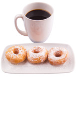 A mug of coffee and homemade doughnut with sugar toppings 