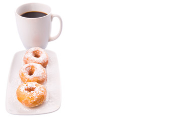 A mug of coffee and homemade doughnut with sugar toppings 