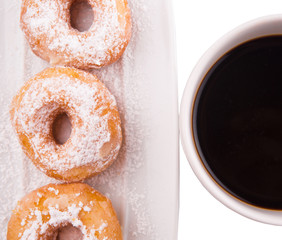 A mug of coffee and homemade doughnut with sugar toppings 