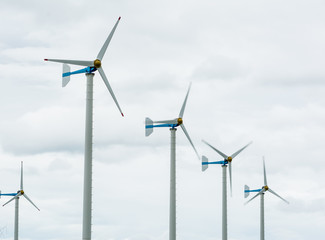 Wind Turbines in wind farm against cloudy sky