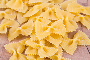 farfalle raw pasta on wooden table