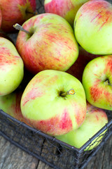 apples in a basket on wooden surface