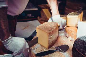 Worker slicing the cheese.  Close up of Cutting cheese.