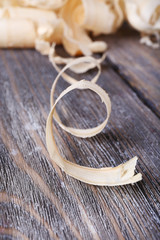 Wood shavings on grey wooden background closeup